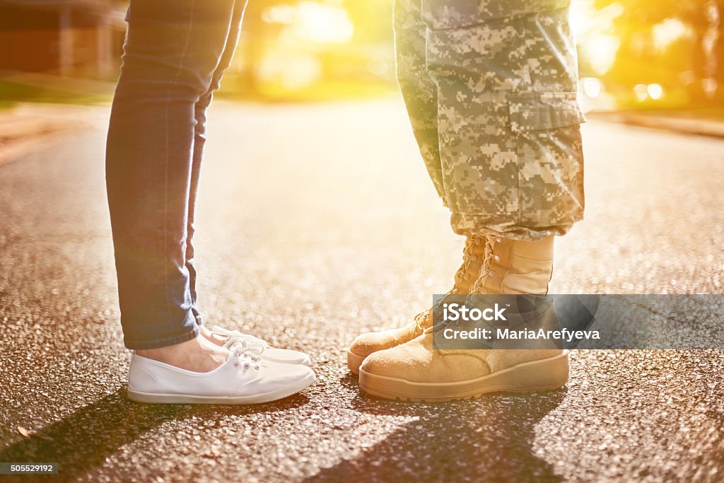 Young military couple kissing each other, homecoming concept, so Young military couple kissing each other, homecoming concept, soft focus,warm orange toning applied Military Stock Photo