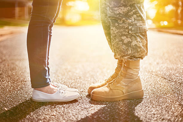Young military couple kissing each other, homecoming concept, so Young military couple kissing each other, homecoming concept, soft focus,warm orange toning applied military deployment photos stock pictures, royalty-free photos & images