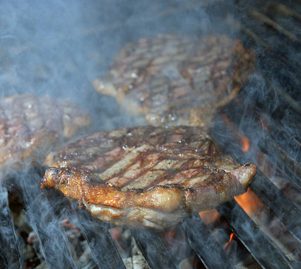istock beef steak cooking on an open flame grill 505531817