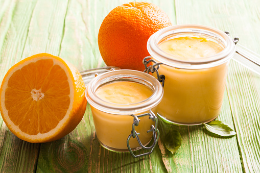 Orange curd in glass jars on the table