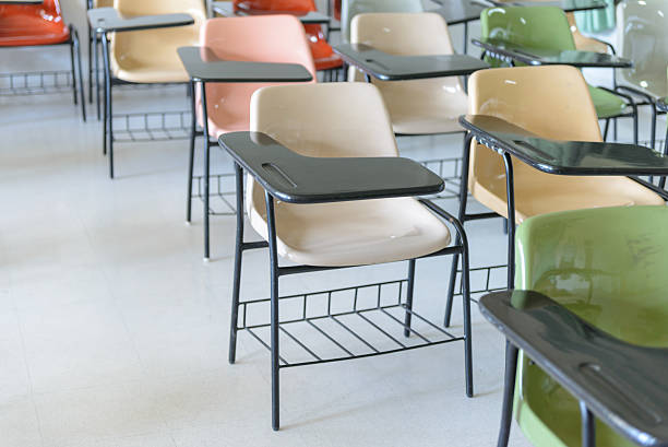 istock Many lecture chairs arranged neatly in empty classroom. 505535254