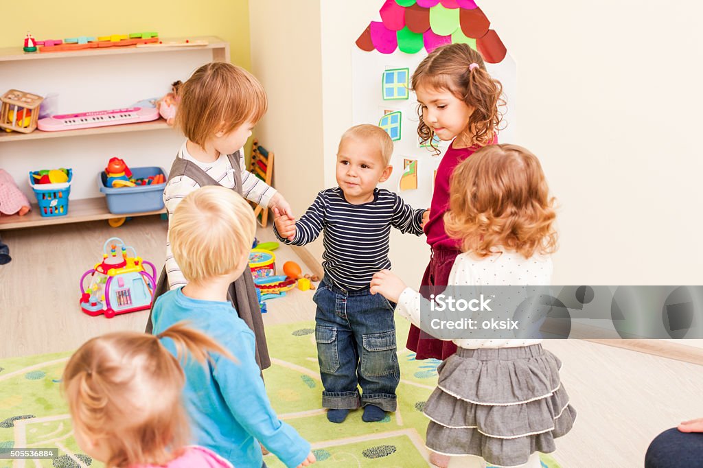 Group of little children dancing Group of little children dancing holding hands and enthusiastically watching the boy, who laughs with joy Dancing Stock Photo