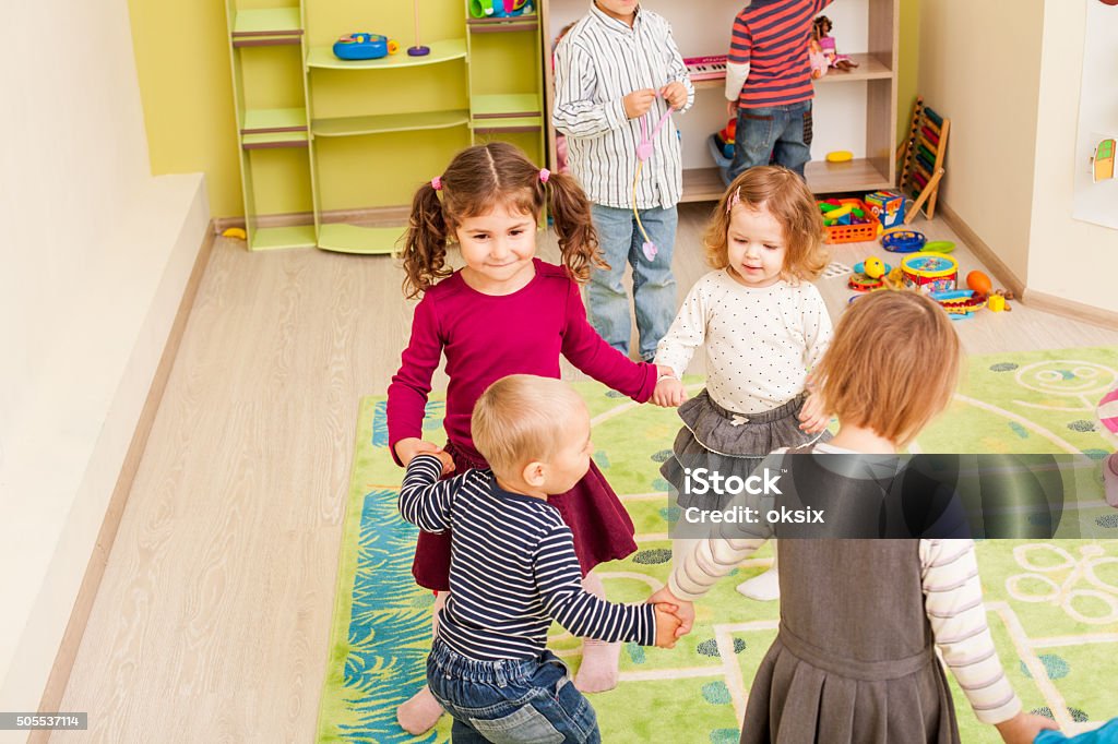 Group of little children dancing Group of little children dancing holding hands and enthusiastically watching the boy, who laughs with joy Child Stock Photo