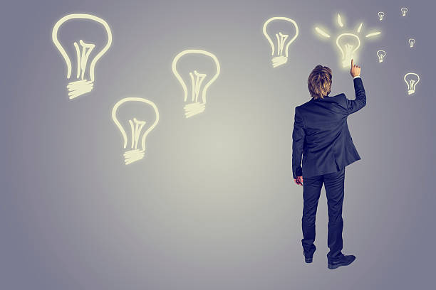 istock Businessman drawing light bulbs in the air 505546723