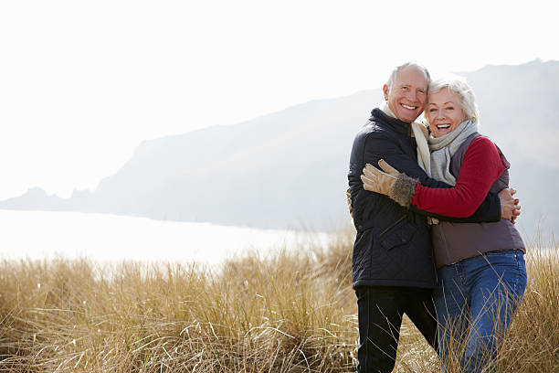 istock Senior Couple Walking Through Sand Dunes On Winter Beach 505547893