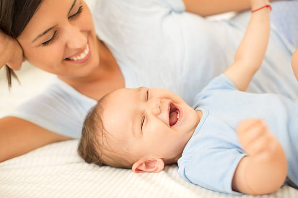 Mother with her baby boy lying on the bed.