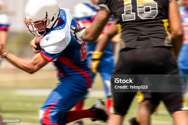 Football Running Back Carries The Ball Defenders Stock Photo - Download Image Now - Adult, American Football - Ball, American Football - Sport