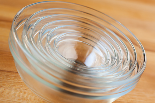Studio photo of stacked group of classic glass food mixing bowls with selective focus on top rim in center