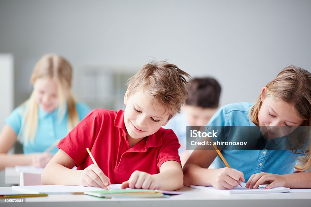 Drawing together Portrait of two diligent pupils drawing at lesson Child Stock Photo