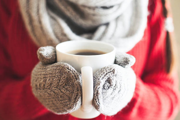 istock Woman hands in gloves holding a mug 505578044