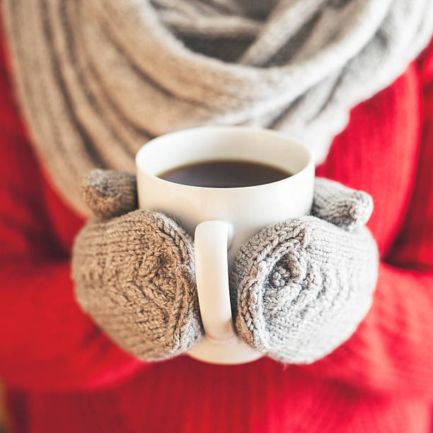 istock Woman hands in  gloves holding a mug 505578070