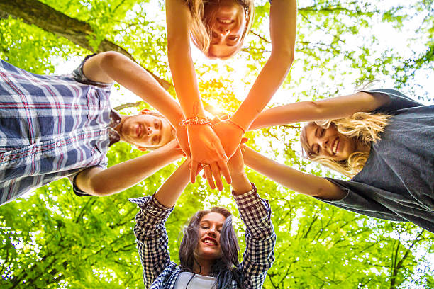 Group of friends with hands in hands - Teamwork stock photo