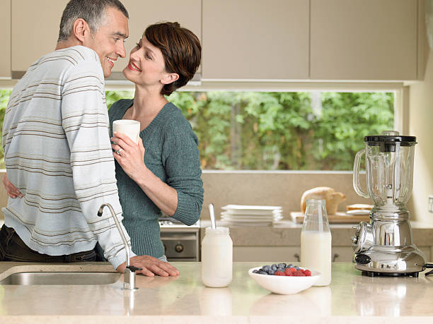 istock Woman Holding Milkshake While Looking At Husband In Kitchen 505583505