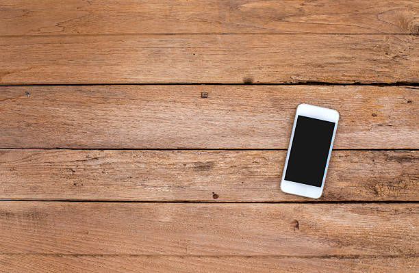 istock Smart phone on old wooden background 505585743
