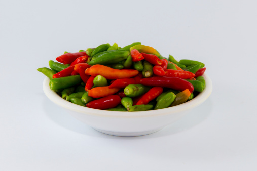 Small multiple color chilies on dish, Isolated
