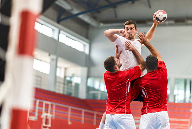 handball player jumping and shooting at goal. - handbal stockfoto's en -beelden