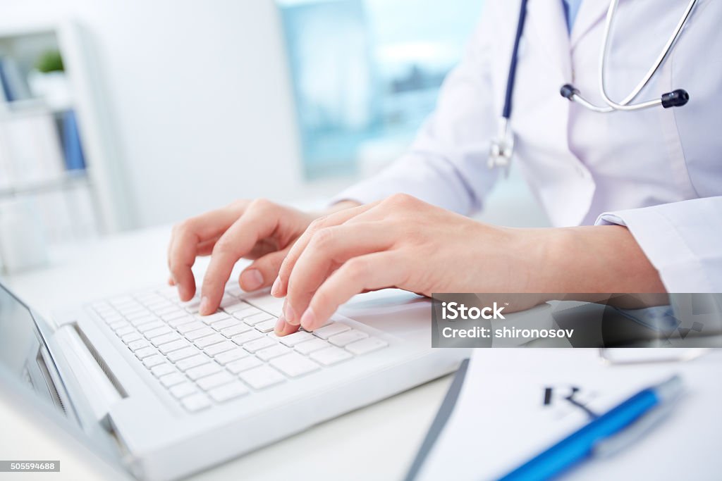 Computerization of healthcare system Close shot of a female doctor studying medical records via laptop Doctor Stock Photo