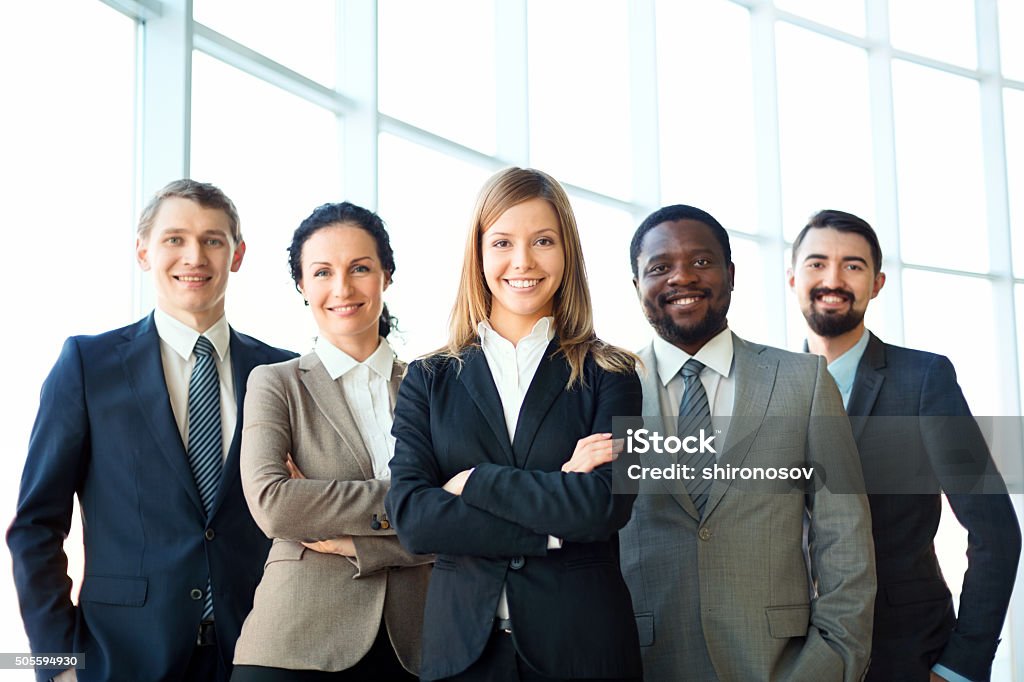 Business group Group of business partners looking at camera with smiles, pretty leader in front Leadership Stock Photo