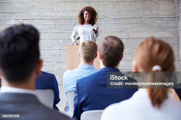 Businesswoman Addressing Delegates At Conference Stock Photo - Download Image Now - Women, Lectern, African Ethnicity