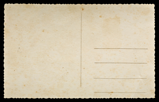 Old paper postcard with decorative edges isolated on black background