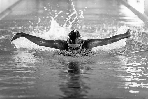 Butterfly style swimmer in action, black and white