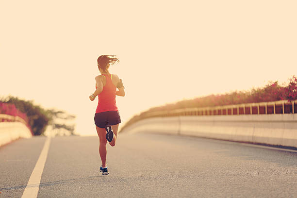 istock young woman runner running on city bridge road 505596870