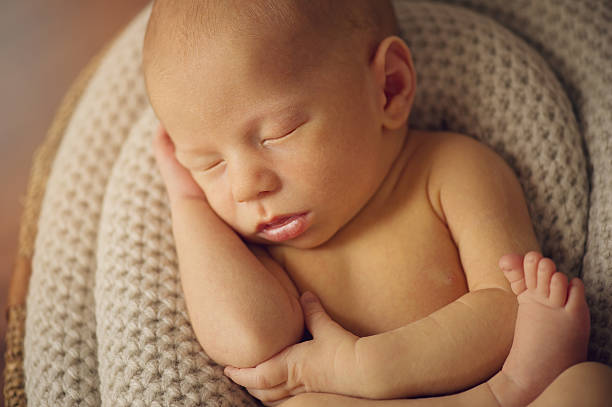 istock Newborn Baby Boy Sleeping Peacefully with Hand 505600523