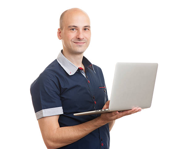 istock smiling bald young man with laptop 505600548