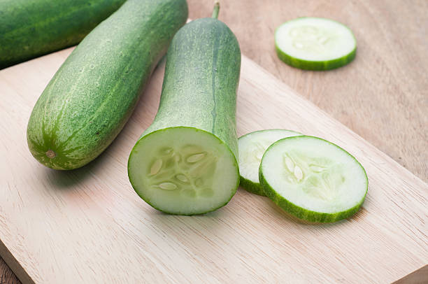 istock Sliced cucumber on wooden cutting board. 505601302