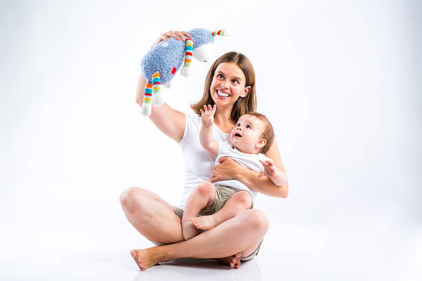 Beautiful mother with her son. Studio shot on gray background.