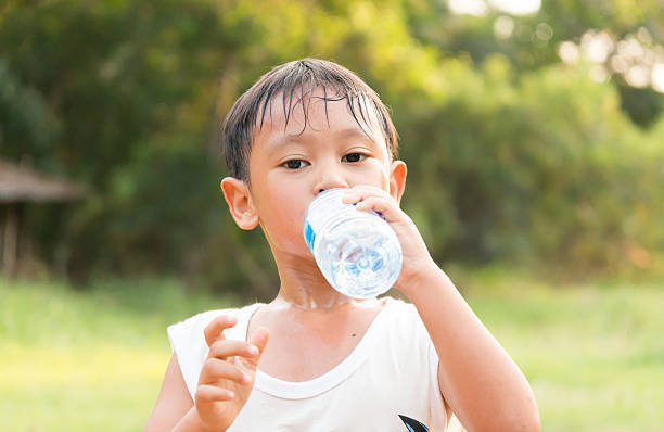 istock Asian boy drinking water from plastic bottle  after a exercise 505601754