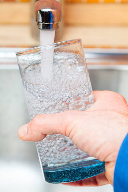 istock Filling up a glass with water from kitchen tap POV 505601958