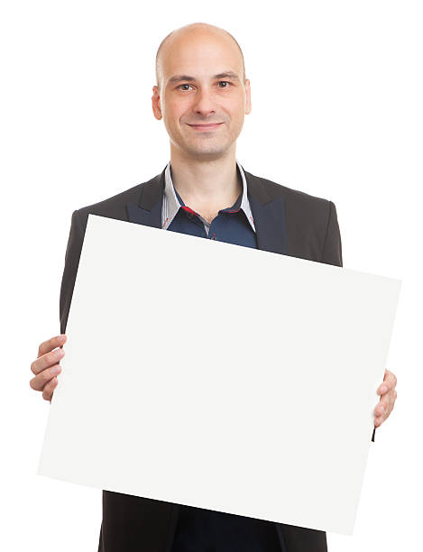 istock bald man holding a blank sheet of paper 505602448