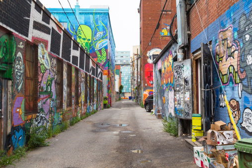 Toronto, Canada - July 19, 2014: A view down Graffiti Alley in Toronto during the day. People can be seen in the distance.