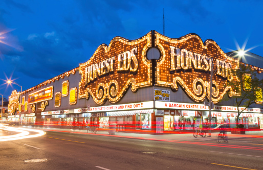 Toronto, Canada - July 30, 2014: The outside of Honest Eds at night in Toronto. People can be seen outside the building.