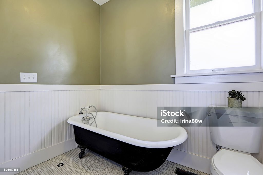 Bathroom with claw foot tub Light green and white bathroom with claw foot tub and vanity cabinet Bathtub Stock Photo
