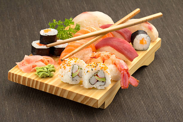 sushi i pałeczki na drewniany talerz - sushi california roll salmon sashimi zdjęcia i obrazy z banku zdjęć