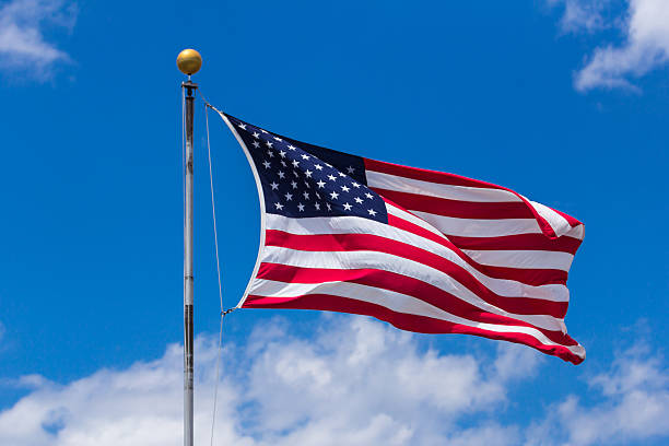 istock American Flag Against Blue Sky 505617275