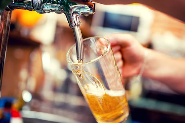 istock barman hand at beer tap pouring draught lager beer 505618769