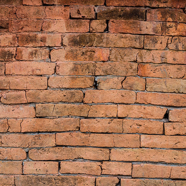 istock Old dark stucco brown and painted red brick wall background 505620259