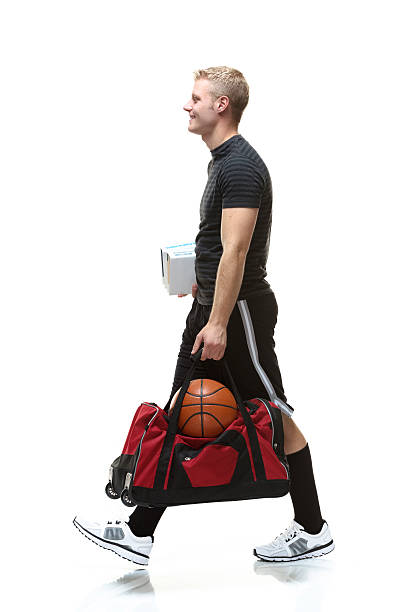istock Smiling student walking & holding bag, books 505621031