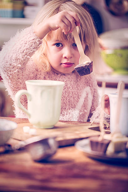istock Cute Little Gril Preparing Hot Chocolate Bar with Spoon 505621130