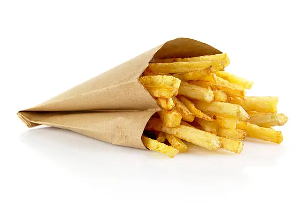Photo of French fries in the paper bag isolated on white