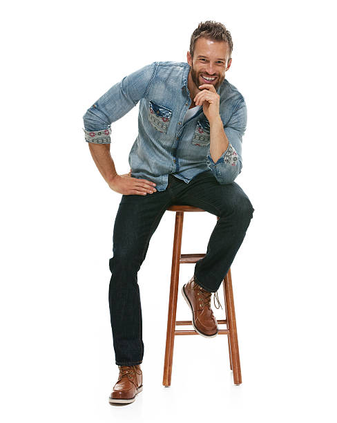 istock Smiling casual man on stool and looking at camera 505624082