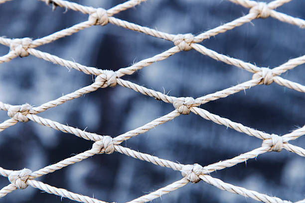 istock Worn rope net on sea background 505624362