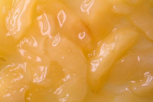 A very close view of canned apple pie filling illuminated by natural sunlight.