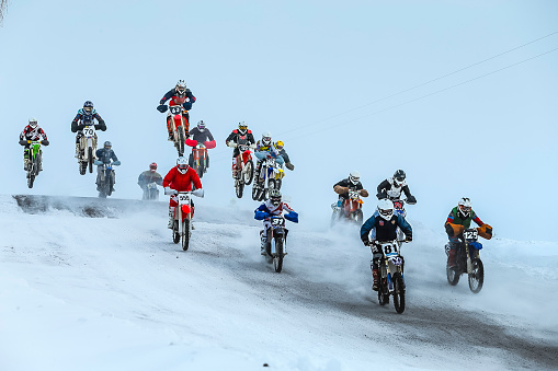 Miasskoe, Russia -  January 16, 2016: group motorcycle racer going on snowy mountain during Cup of Urals winter motocross