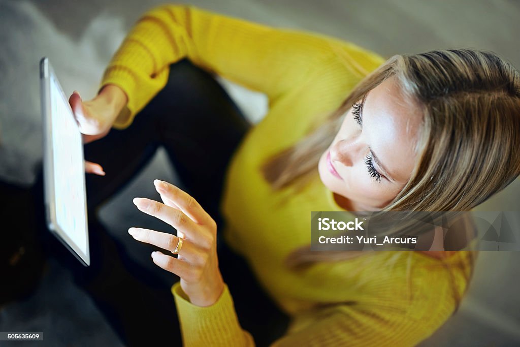 The brave new world of cyberspace Shot of an attractive blonde woman relaxing at home with a digital tablet 20-29 Years Stock Photo
