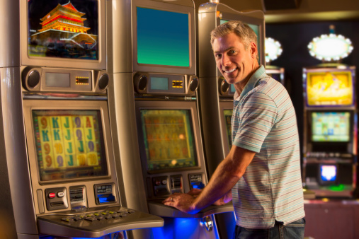 Man On Slot Machines Stock Photo - Download Image Now - Men, Slot Machine, Casino - iStock