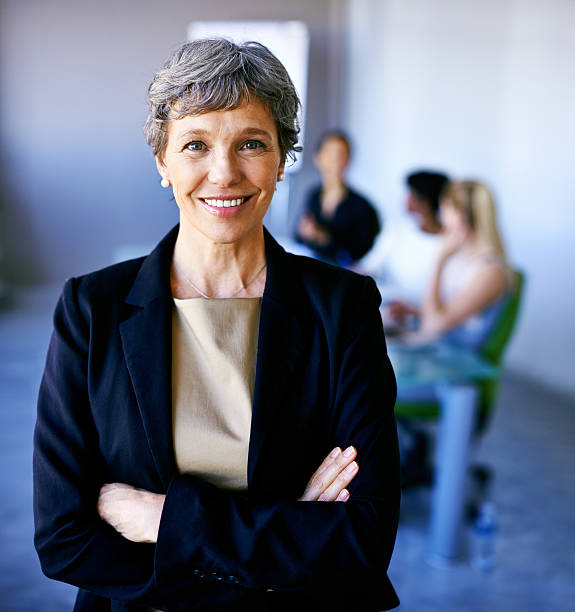 Let's get successful! Portrait of a businesswoman standing in front of her colleagues during a meeting incidental people photos stock pictures, royalty-free photos & images
